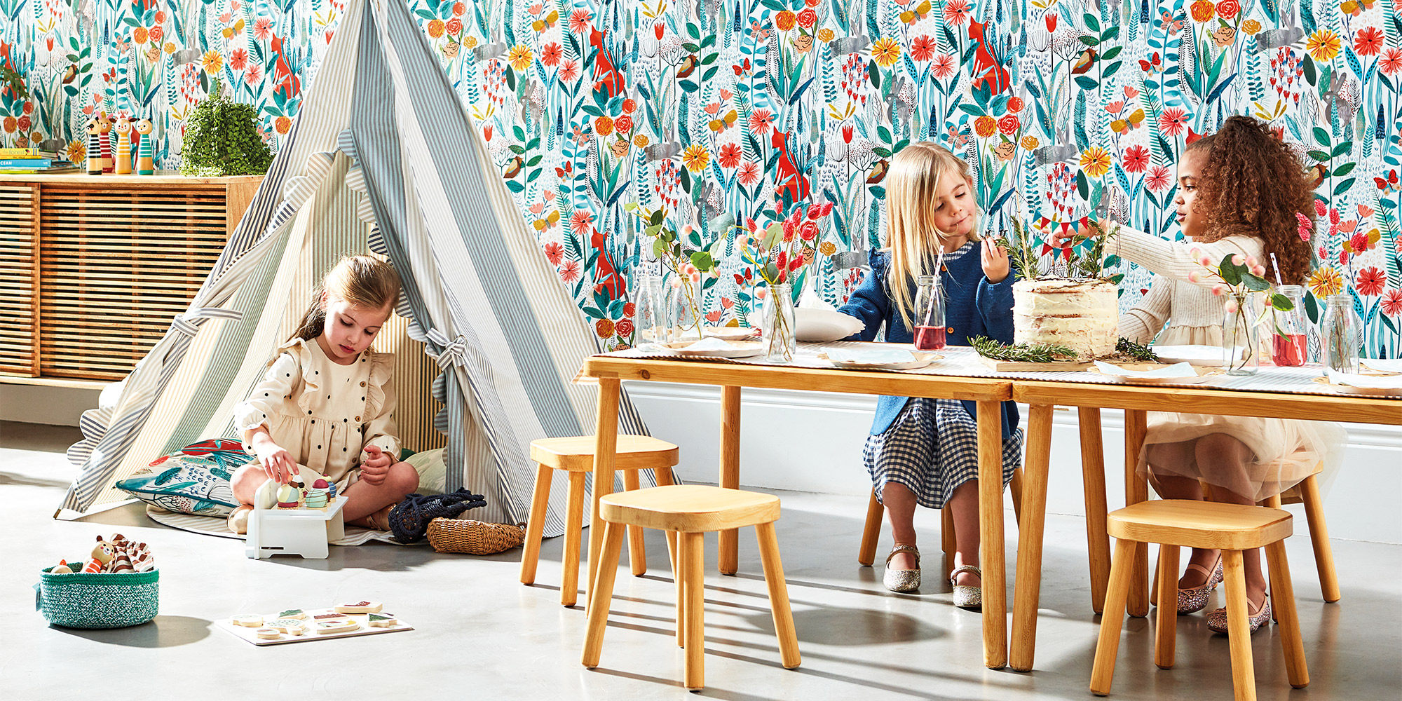 Bunte Blumentapete für Mädchen mit einer Blumenwiese in blau, rot und orange.