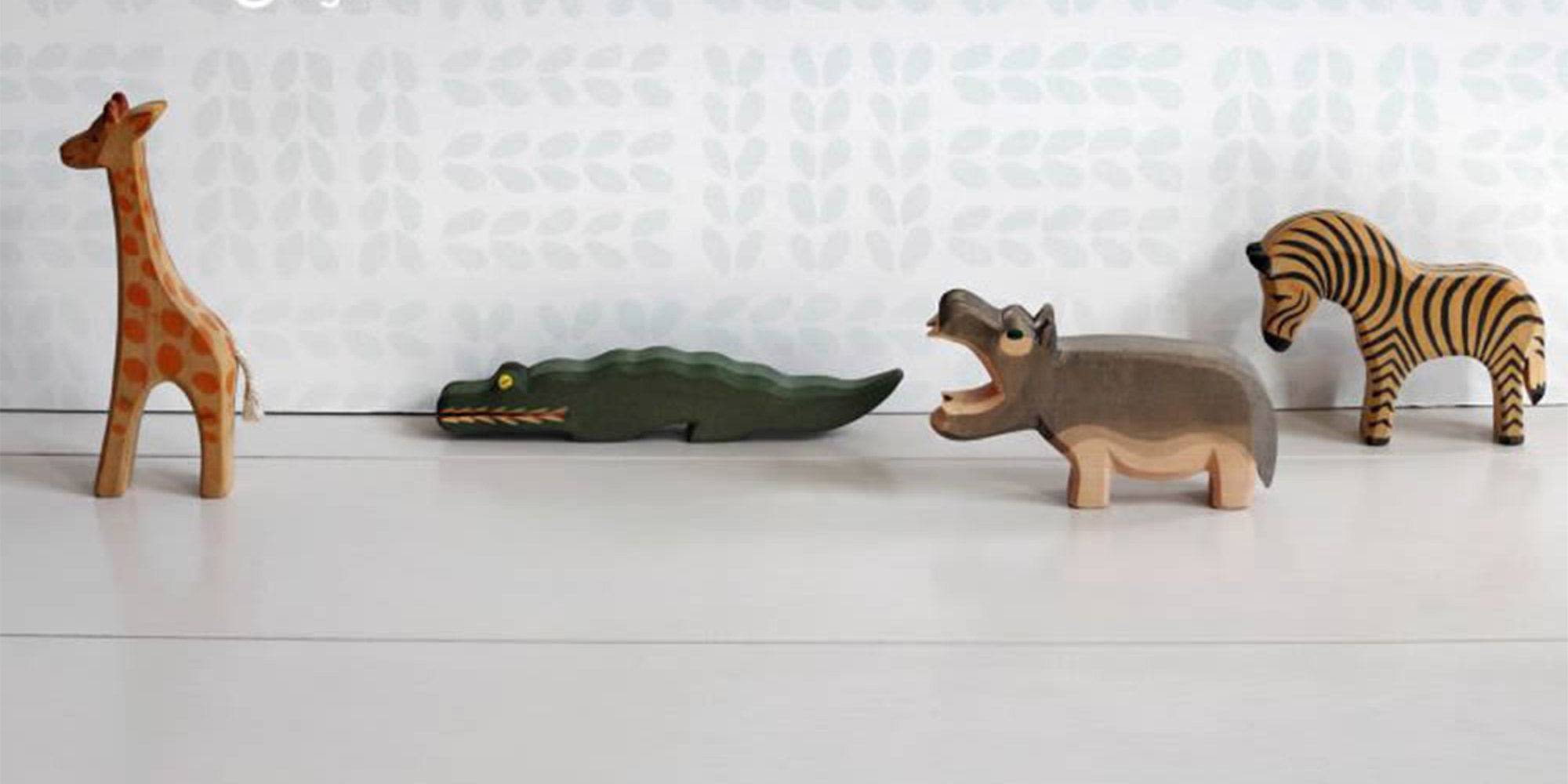 Weiße Tapete für das Kinderzimmer mit dezentem Blütenmuster in hellem grau.