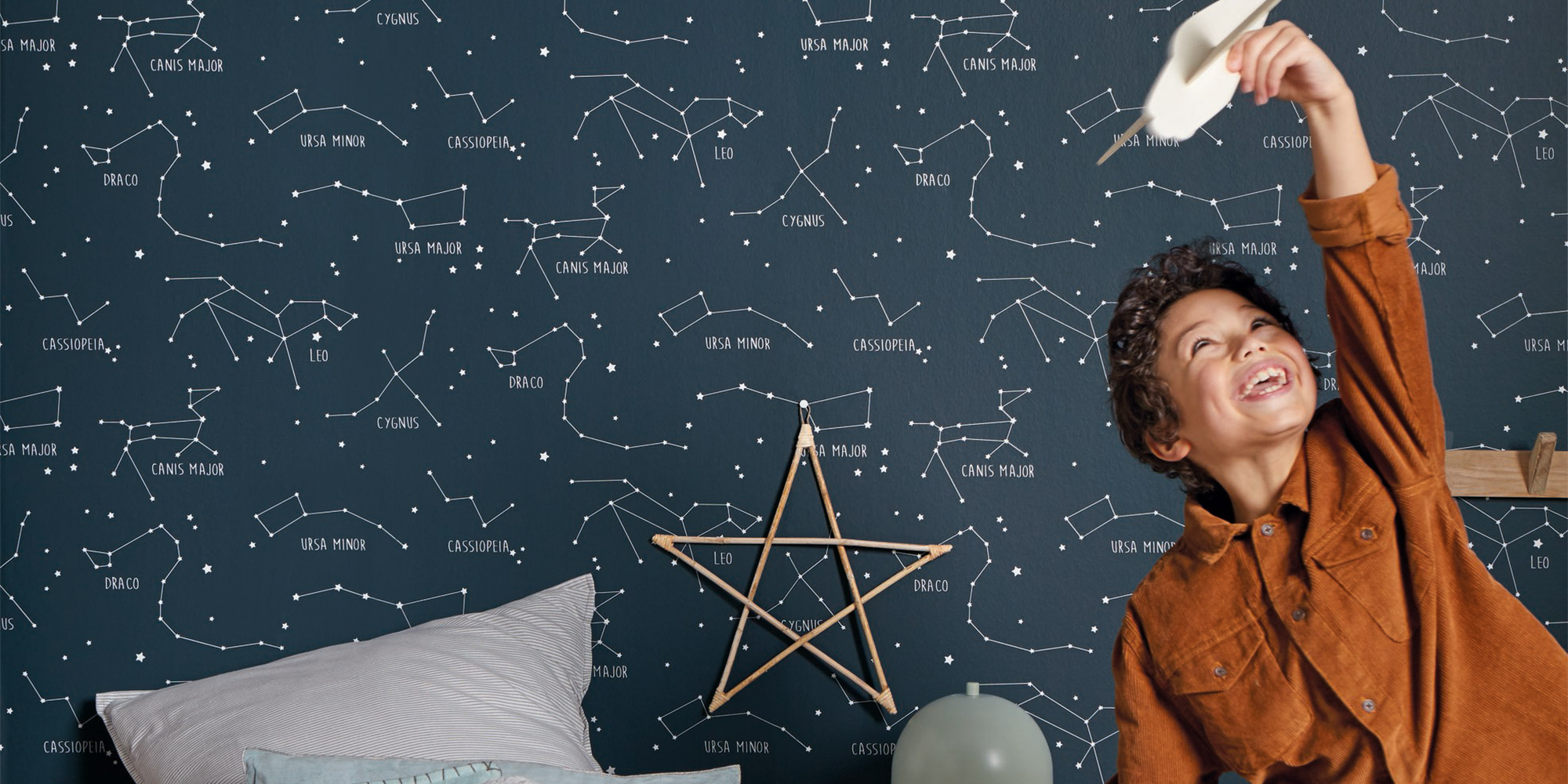 Kinderzimmertapete in dunklem Blau mit Sternenbildern