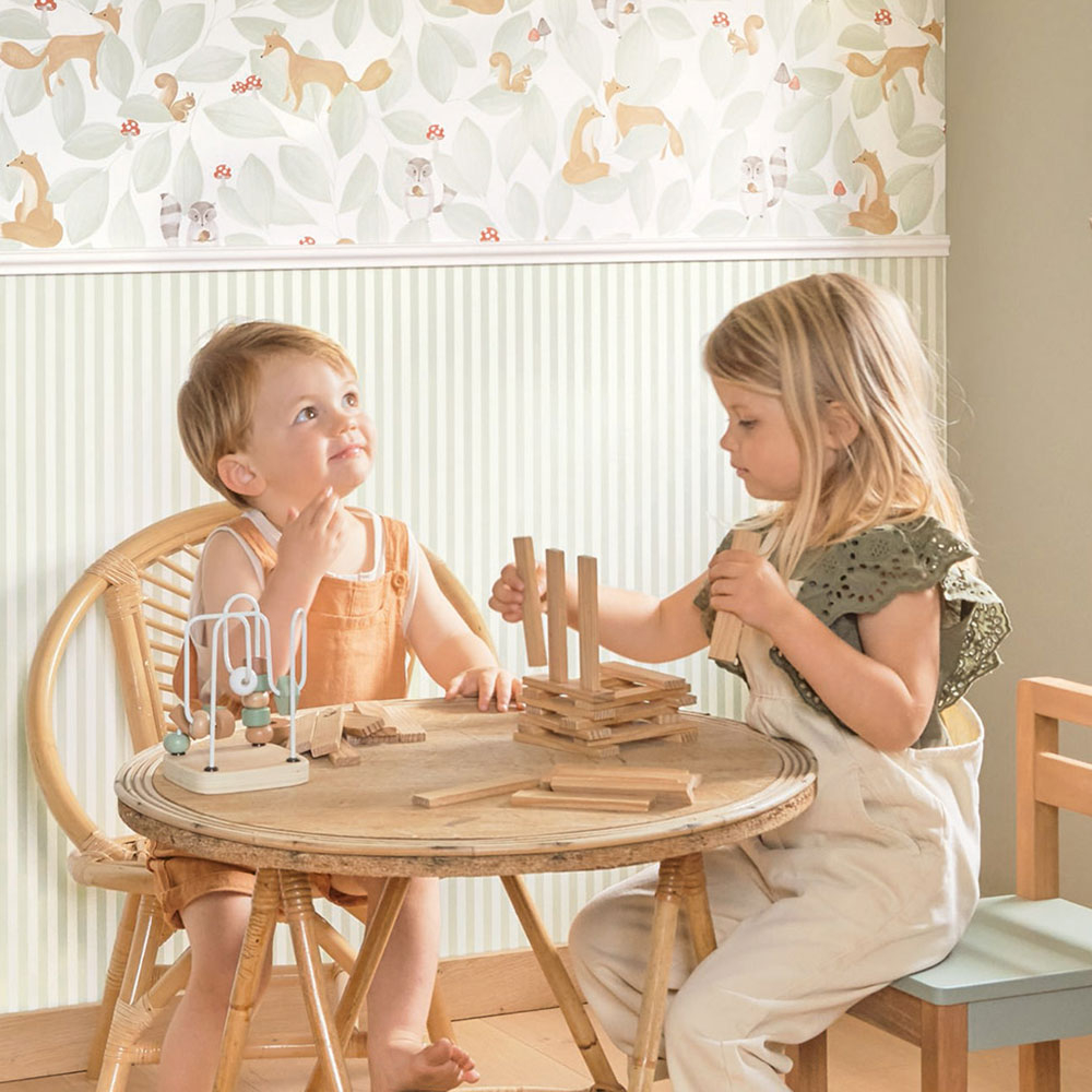 Begriffe rund um Tapeten einfach erklärt Zwei Kinder spielen am Tisch vor Tiermotiv-Tapete