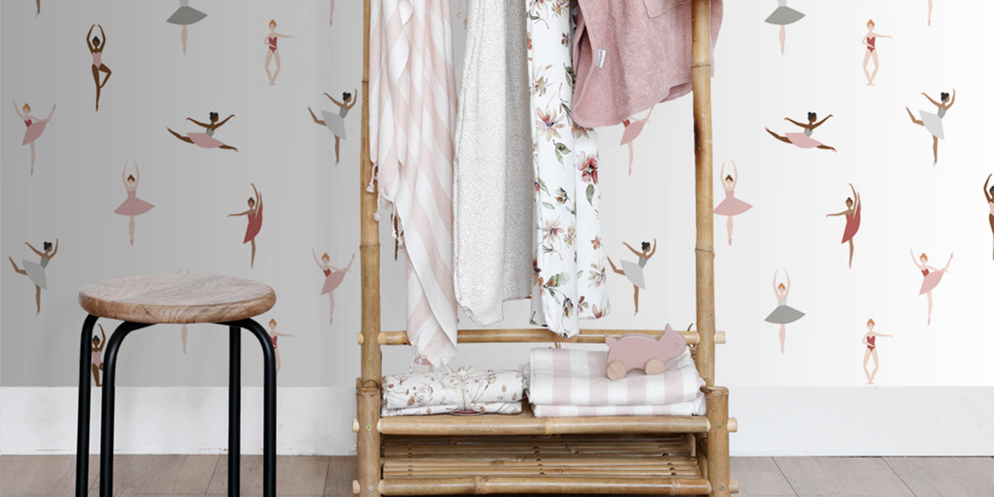 Eine weiße Tapete mit pastellfarbenen Ballerinas.