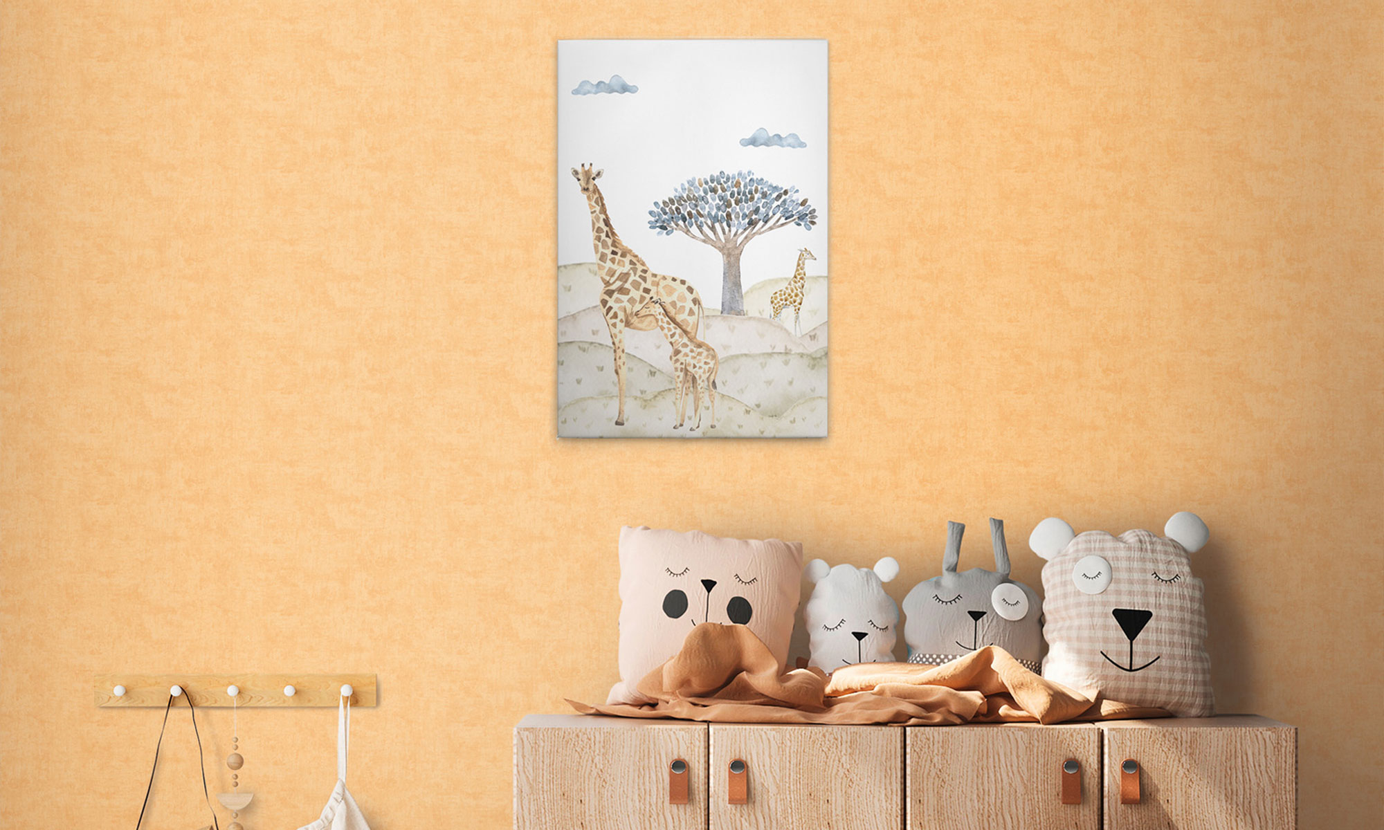Kinderzimmer mit orangefarbener Strukturtapete, Giraffen-Wandbild und dekorativen Tierkissen auf einer Holzkommode