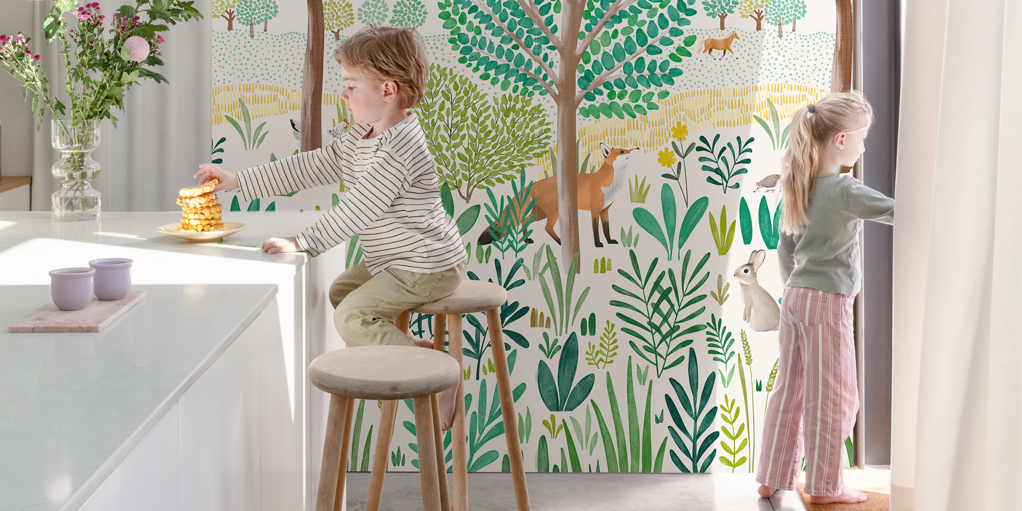 Ein Wandbild mit Waldmotiven als Wandgestaltung in einer modernen, schlichten weißen Küche.