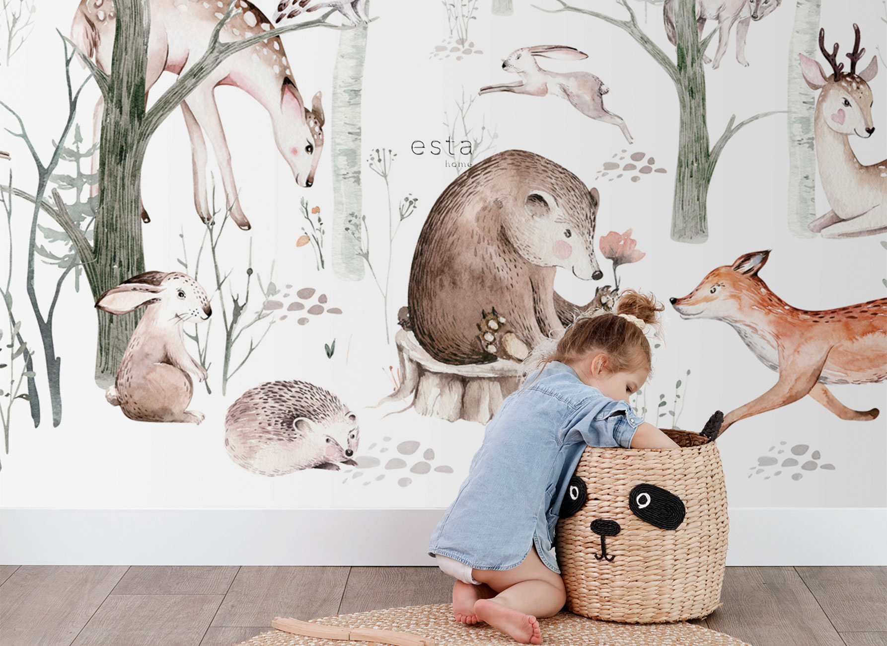 Kind sitzt vor einer hellen Waldtier-Tapete mit Reh, Bär, Fuchs, Hase und Igel im Kinderzimmer