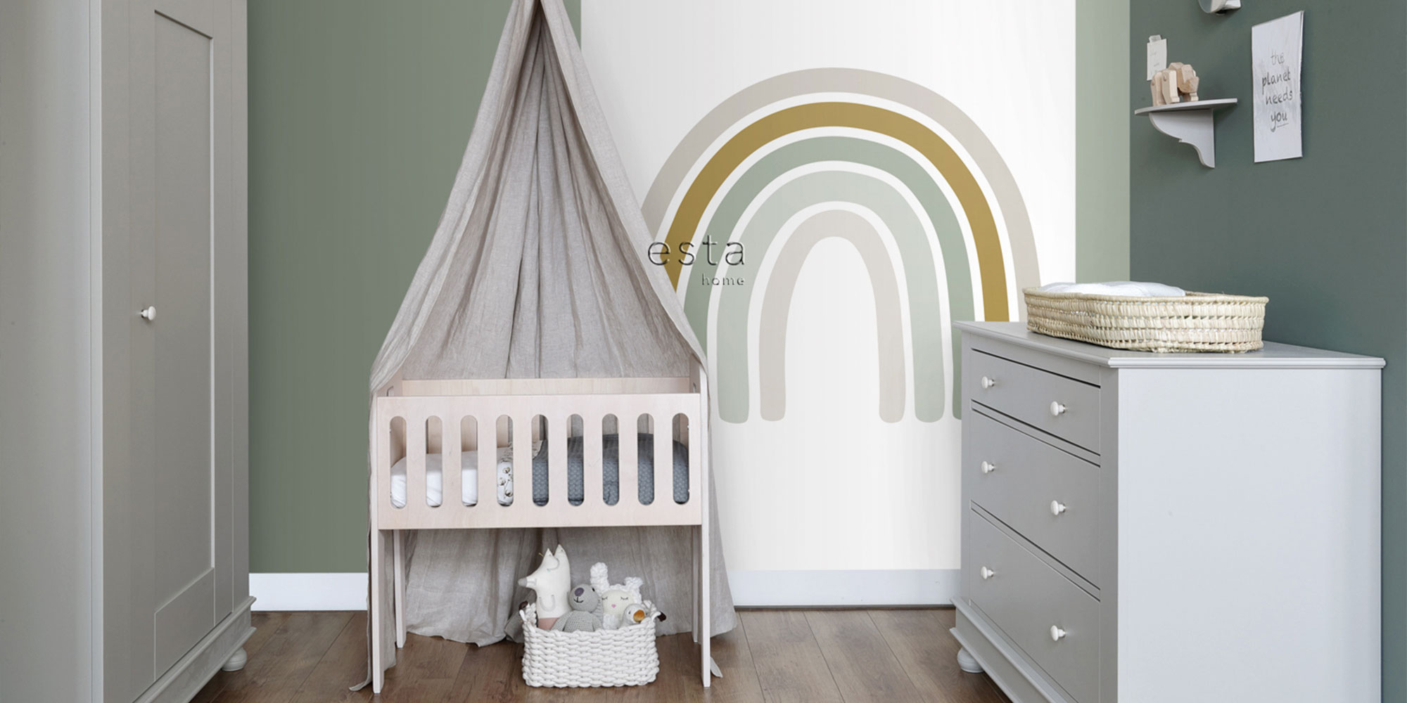 Babyzimmer mit Regenbogen Wandmotiv in Grün Beige und Senfgelb hinter Babybett im skandinavischen Stil