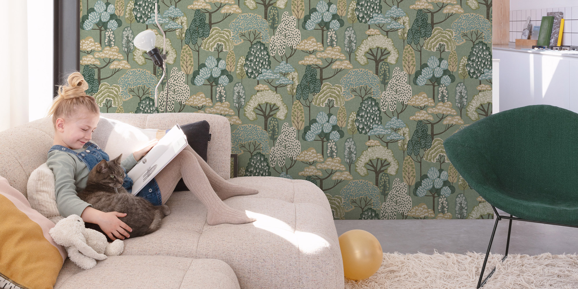 Eine grüne Waldtapete mit Bäumen als Wandgestaltung im Wohnzimmer.