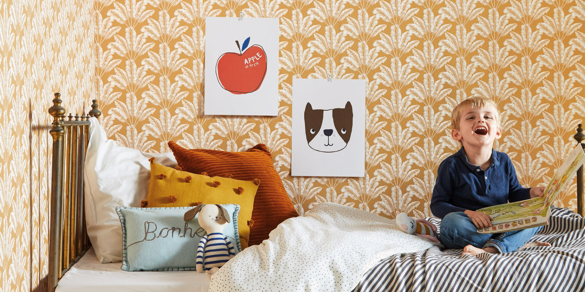 Currygelbe Vliestapete mit natürlichen Blattmotiven.