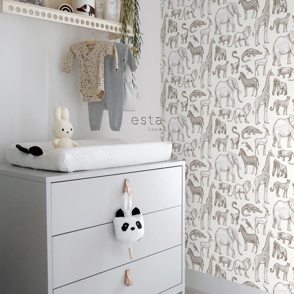 Weiße Tier-Tapete im Babyzimmer mit Safari-Tieren, Wickelkommode, Babykleidung und Hasen-Kuscheltier als liebevolle Wandgestaltung