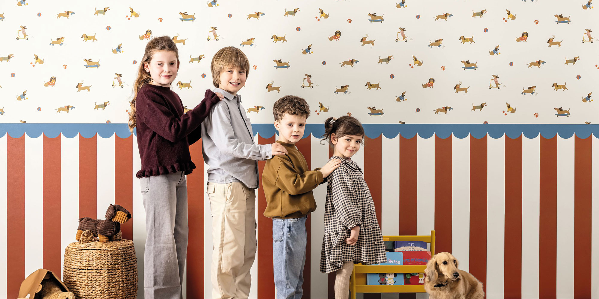 Kids room with childrens wallpaper featuring dachshund dogs and colorful balls on light background with red and blue striped wall