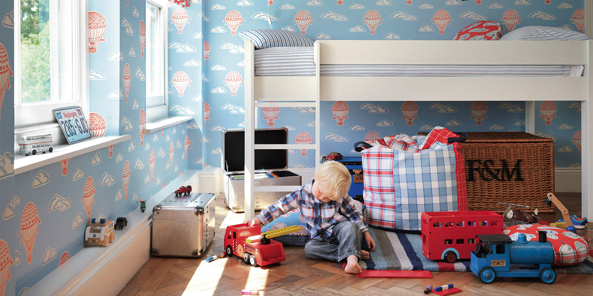 Hellblaue Tapete für das Kinderzimmer mit Wolken und Heißluftballons.