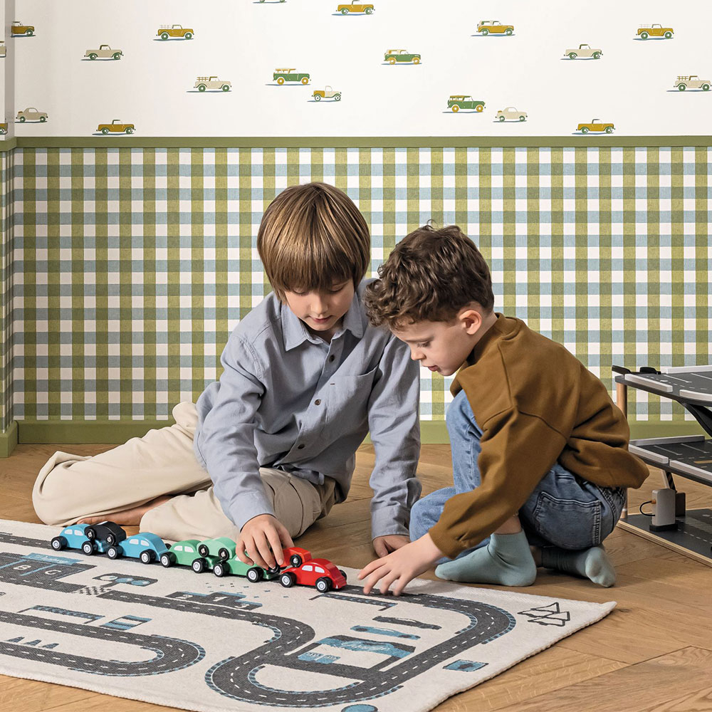Kinderzimmer mit gruener Karo Tapete im unteren Wandbereich und Autotapete mit kleinen Fahrzeugen im oberen Bereich