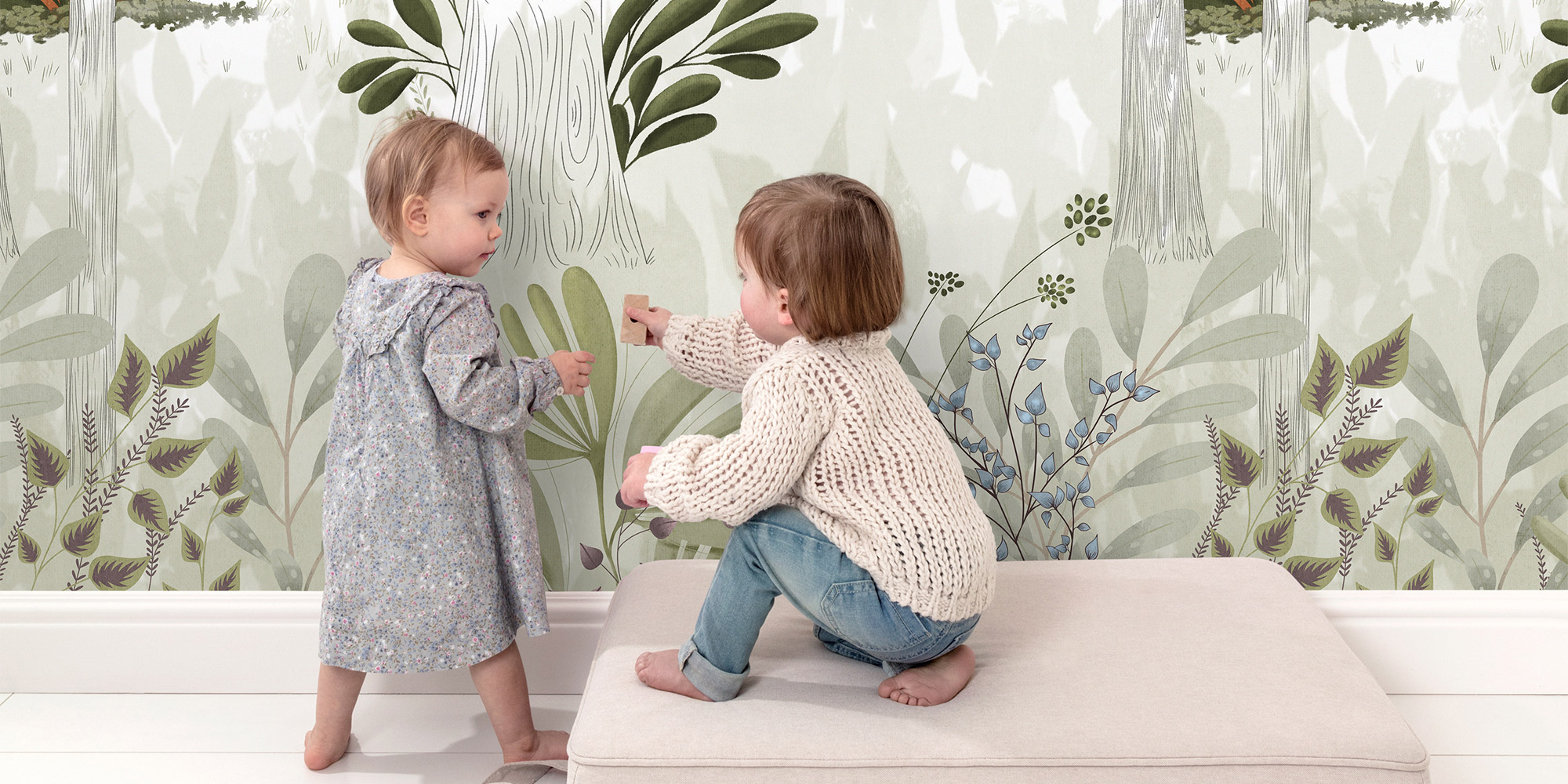 Zwei Kleinkinder spielen vor einer sanften Waldtapete in Pastellfarben