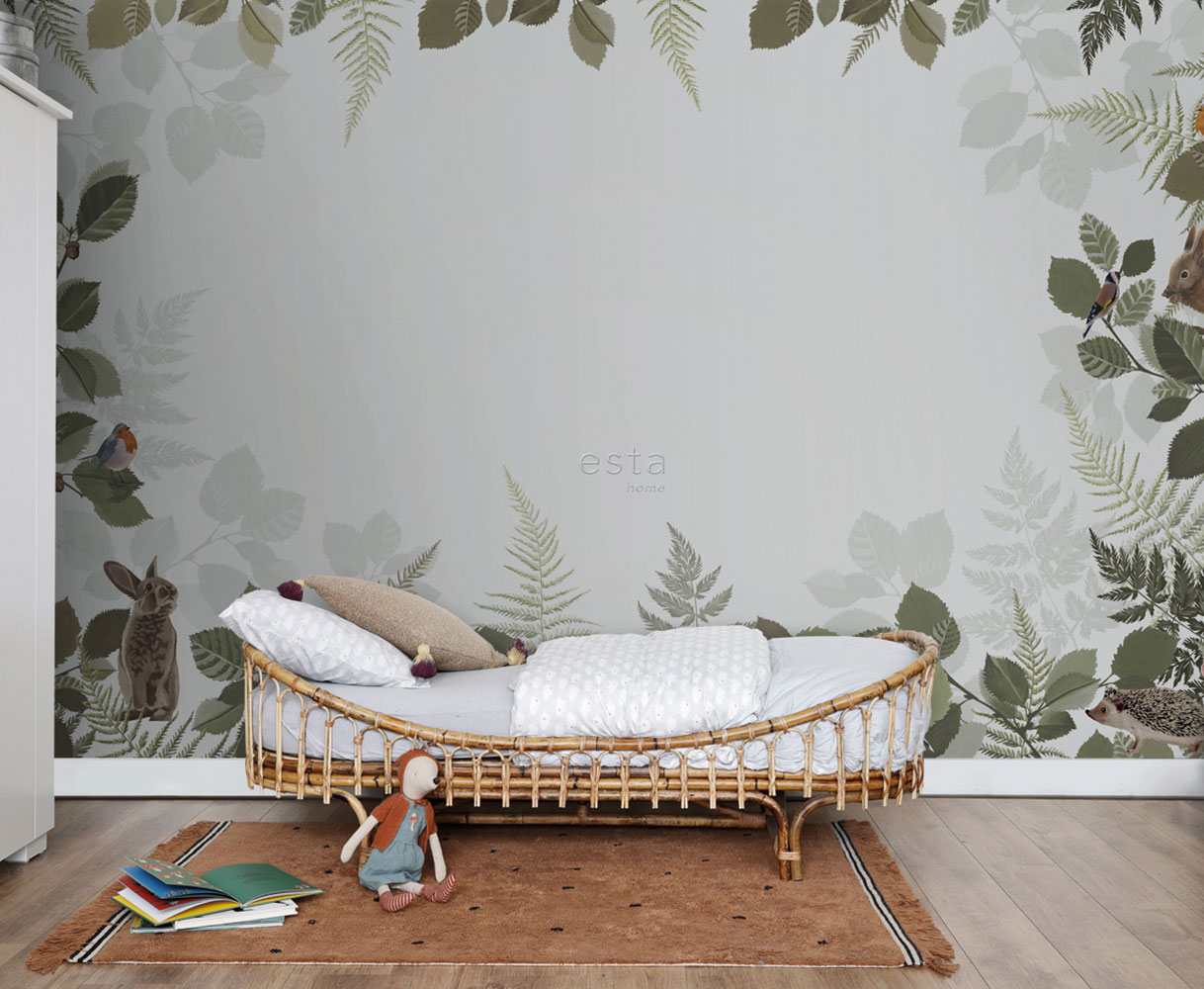 Natürlich gestaltetes Kinderzimmer mit Rattanbett und botanischem Wandbild mit Blättern, Vögeln und Waldtieren