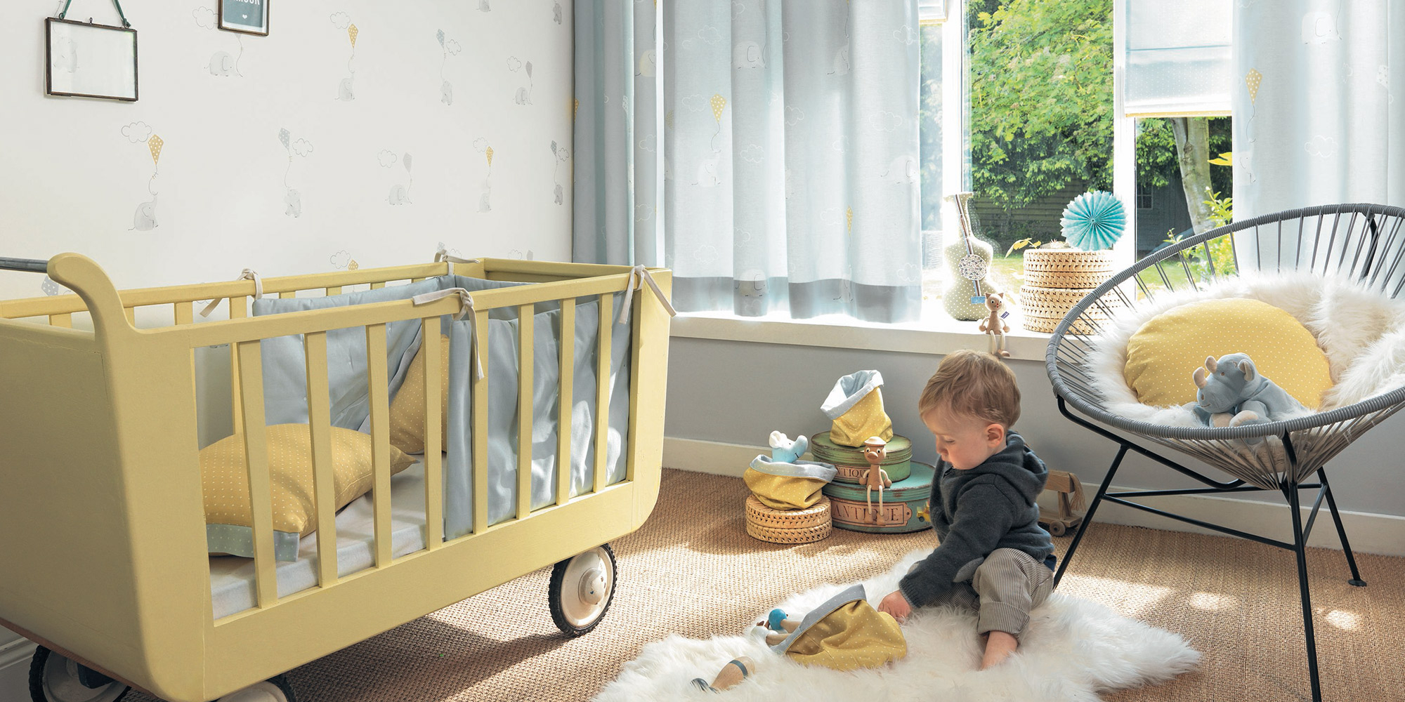 Graue Kinderzimmergardinen mit kleinen Elefanten und bunten Papierdrachen.