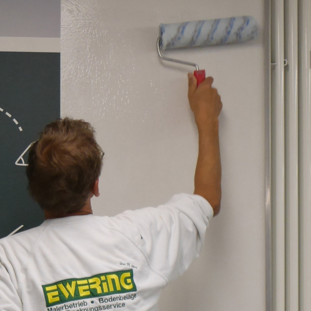 Der Kleister wird mit einer Rolle aufgetragen. Mit Hilfe einer Rolle wird die Wand zum Tapezieren eingekleistert.