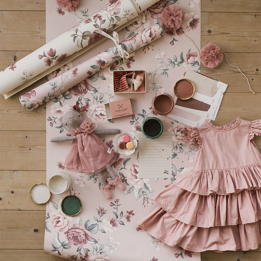 Tapetenpflege-Tipps für Kindertapeten. Rosa Blumentapete mit Stoffmustern und Kindersachen