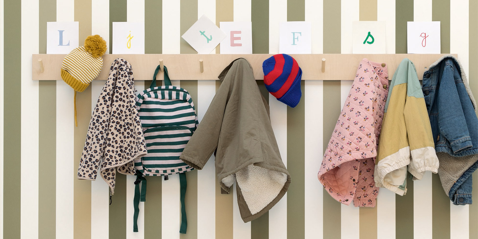 Grüne Streifentapete von Caselio als zeitlose Wandgestaltung im Kinderzimmer.