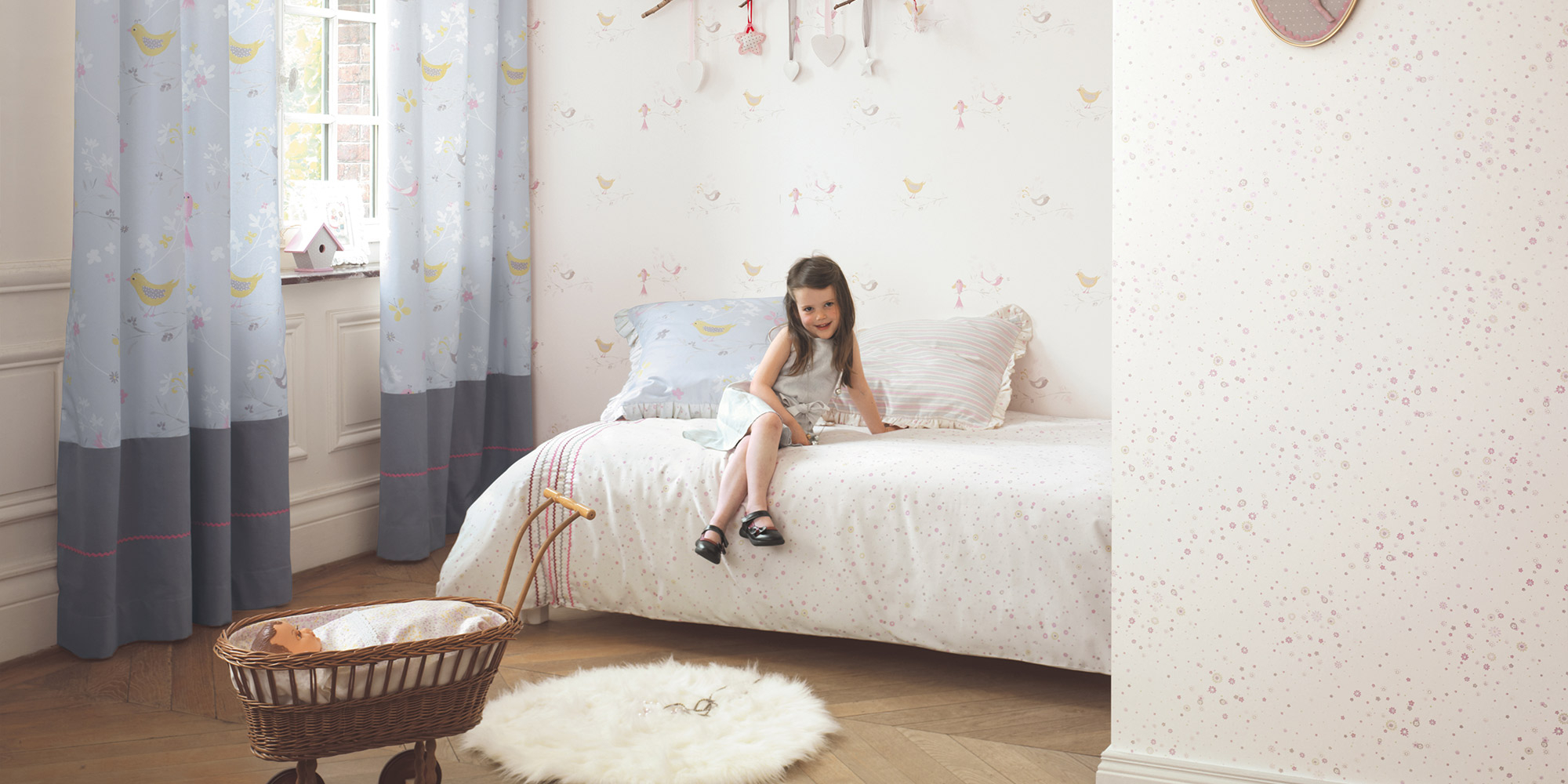 Weiße Kindertaete mit kleinen bunten Vögelchen von Casadeco.